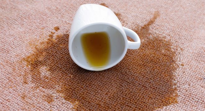koffiekopje gevallen op het kleed, koffie eruit gemorst